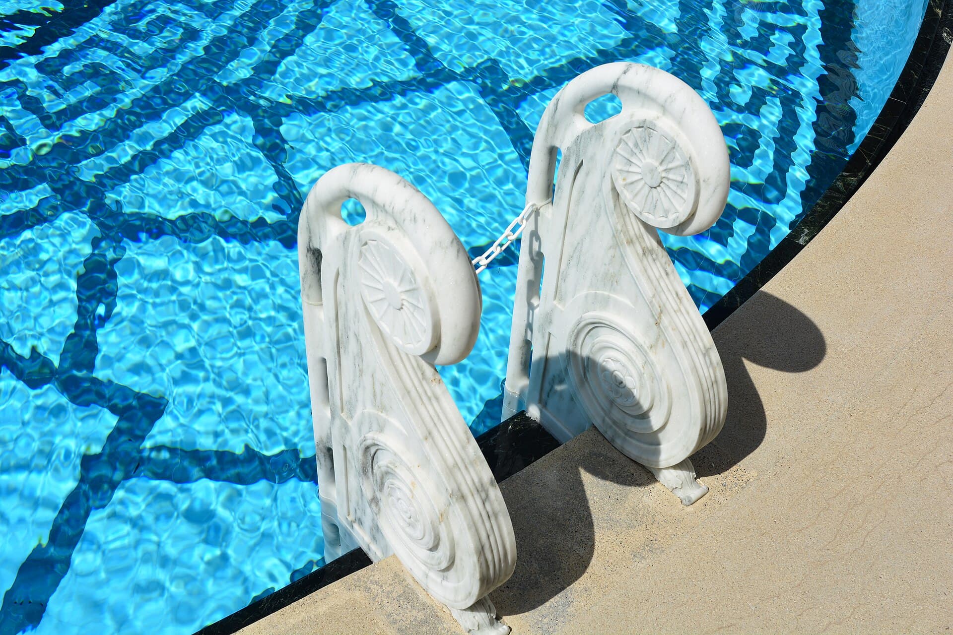 Submerged pool steps with clear blue water and tiled risers leading into a swimming pool