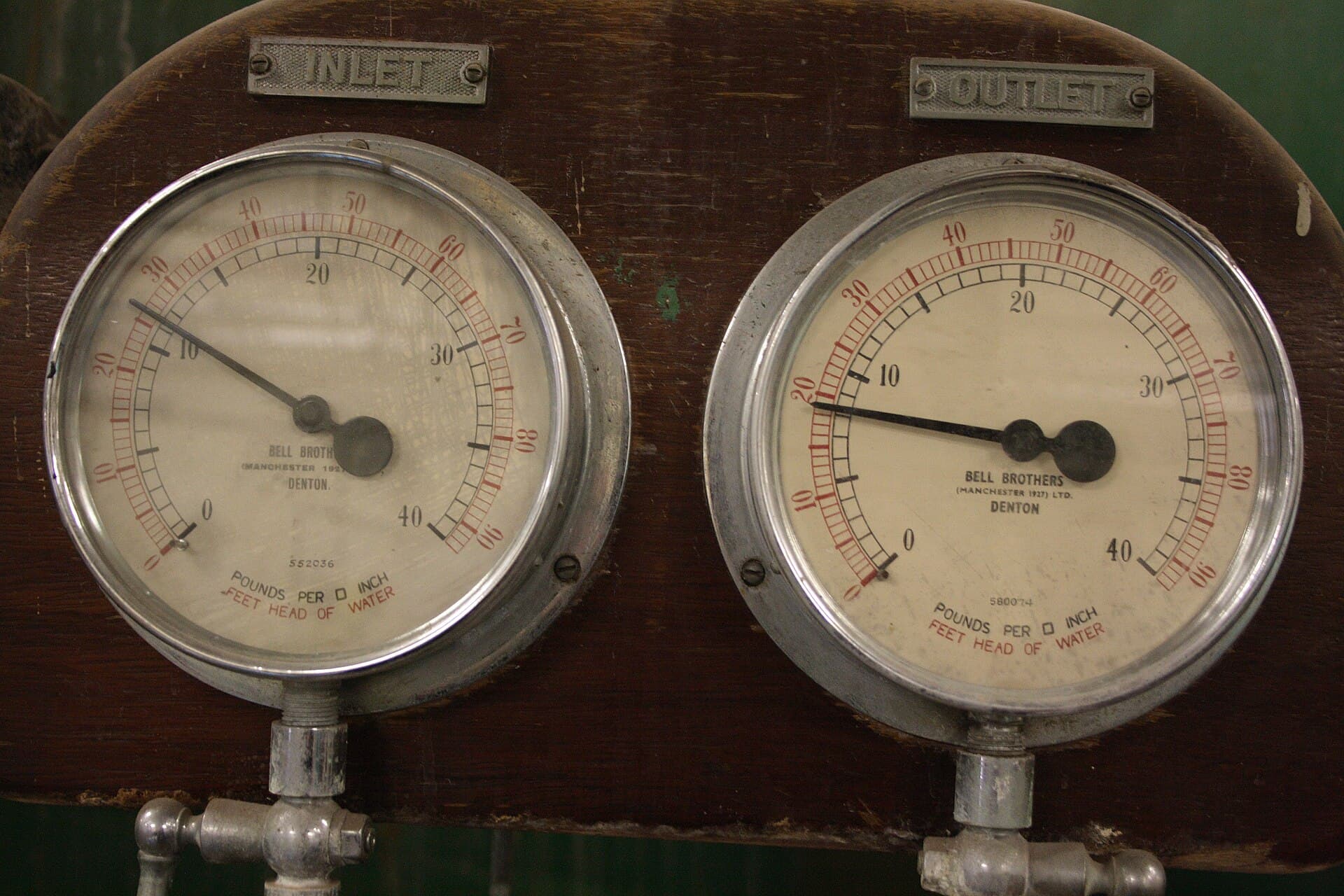 Close-up of inlet and outlet pressure gauges on swimming pool filtration equipment