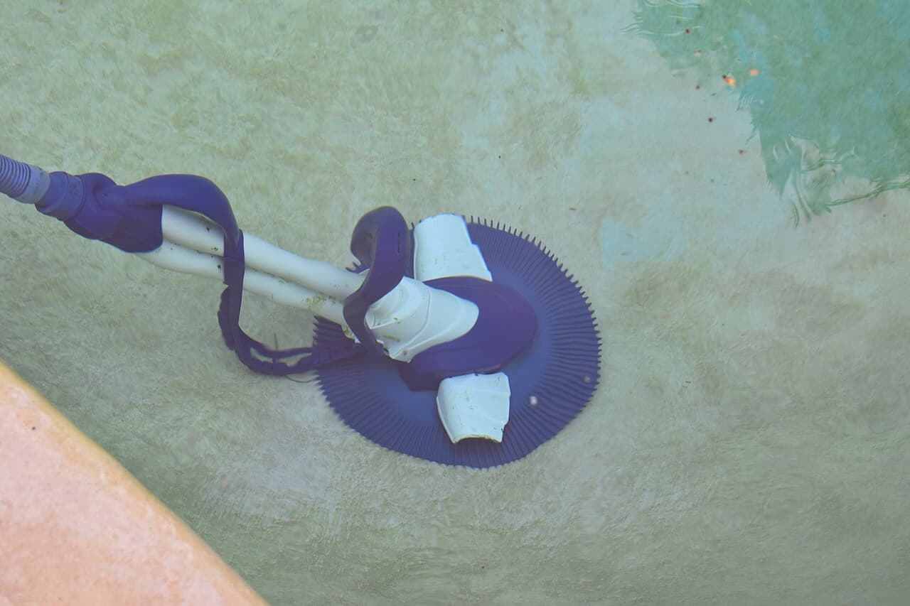 Robotic pool cleaner working along the floor of a swimming pool
