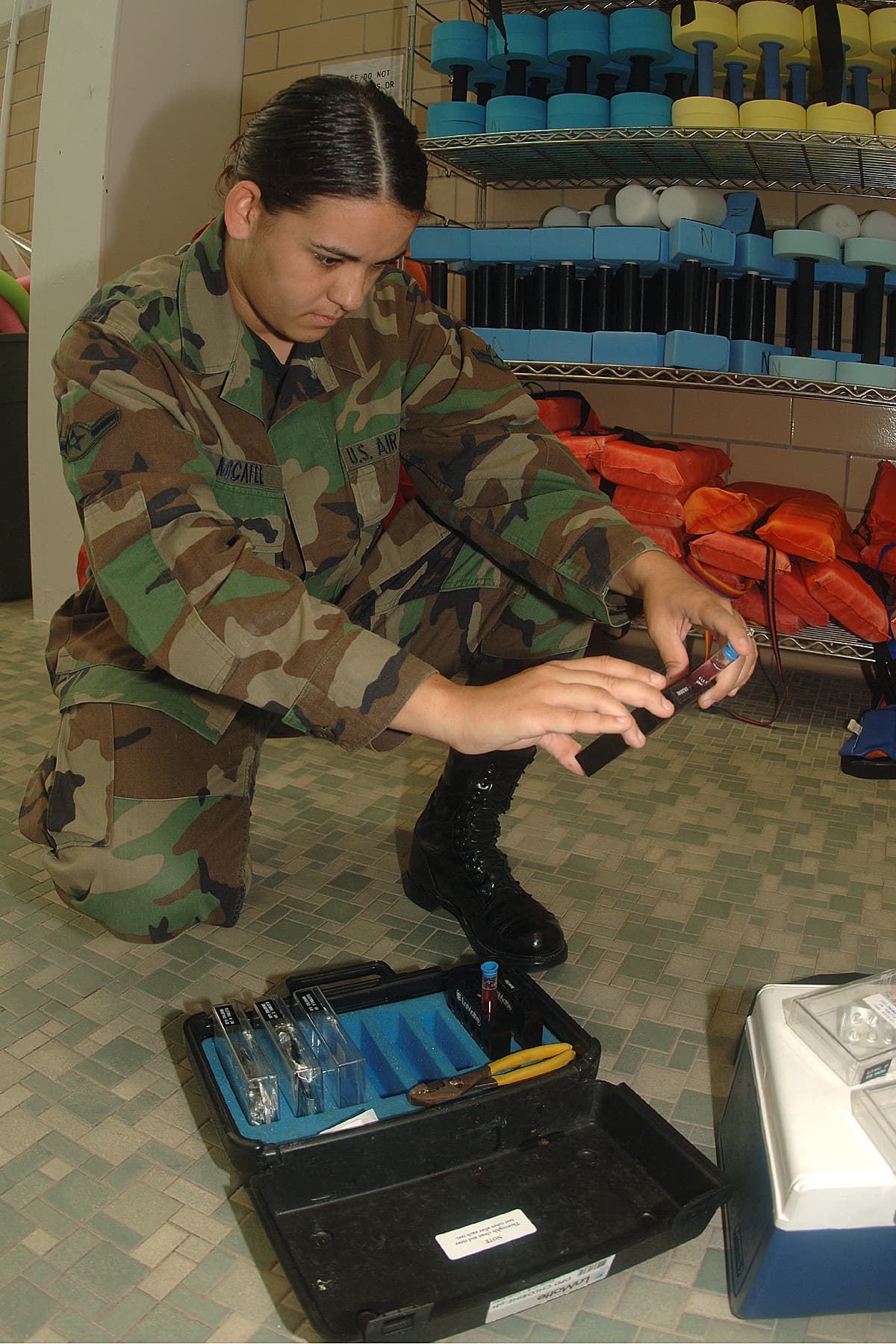 Technician testing a pool water sample for chlorine and pH with a water chemistry test kit
