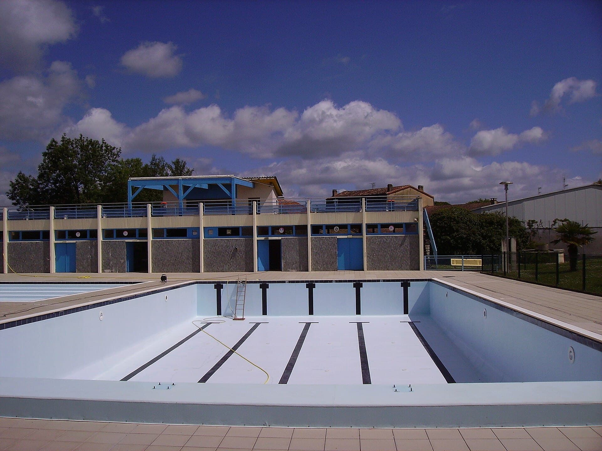 Fully drained swimming pool with exposed floor and walls awaiting inspection and repair